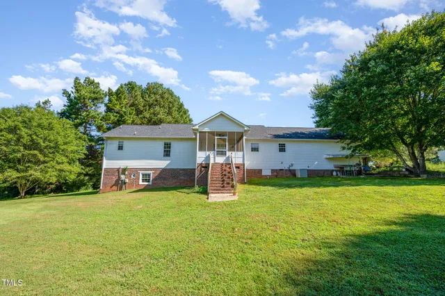 a view of a house with backyard and a tree