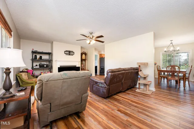 a living room with furniture and a dining table with wooden floor