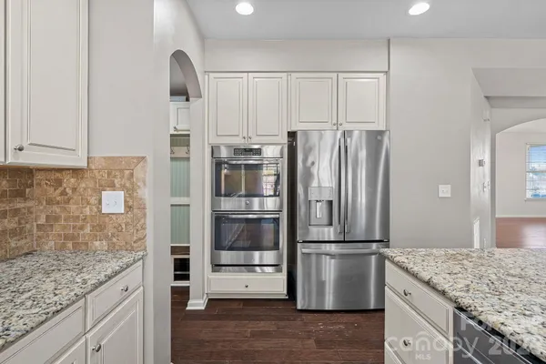 a kitchen with granite countertop a refrigerator and a sink