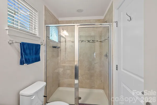 a bathroom with a shower a toilet and a sink