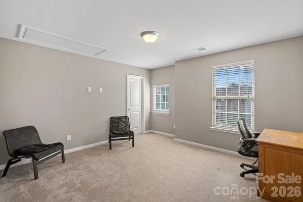 a view of a workspace with furniture and a window