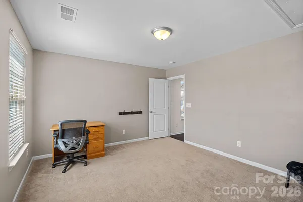 a living room with furniture and a air conditioner vent