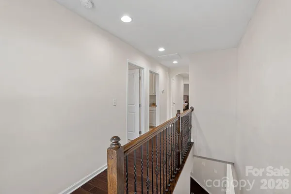 a view of a hallway with wooden floor and staircase