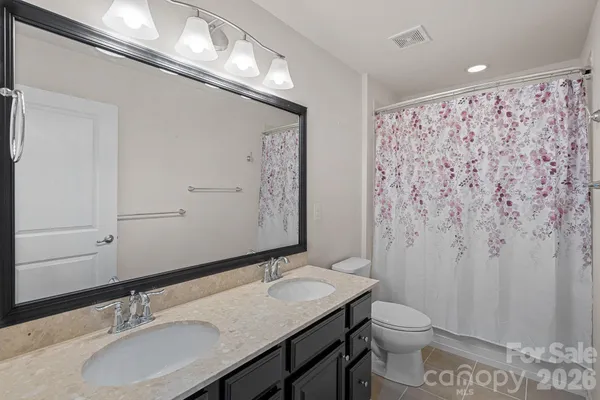 a bathroom with a granite countertop sink toilet and a mirror