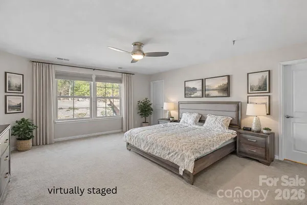 a bedroom with a large bed and a chandelier