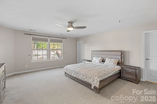 a bedroom with a large bed and a chandelier