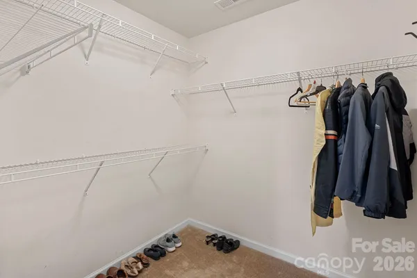 a view of walk in closet with clothes and shoes