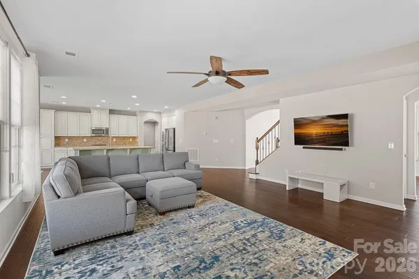 a living room with furniture and a wooden floor