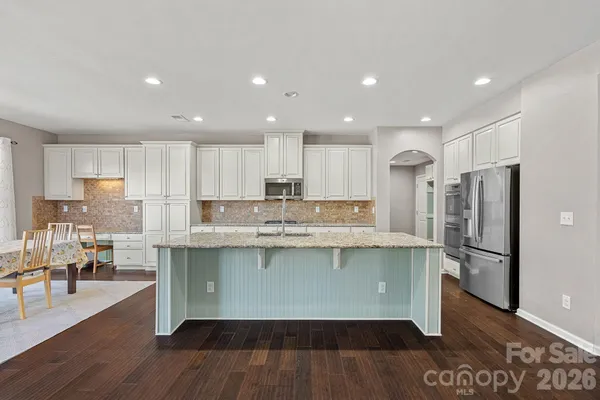a kitchen with stainless steel appliances granite countertop a refrigerator and a stove top oven