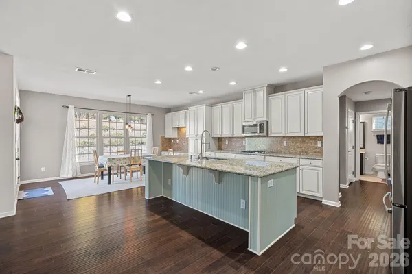 a kitchen with a sink and wooden floor