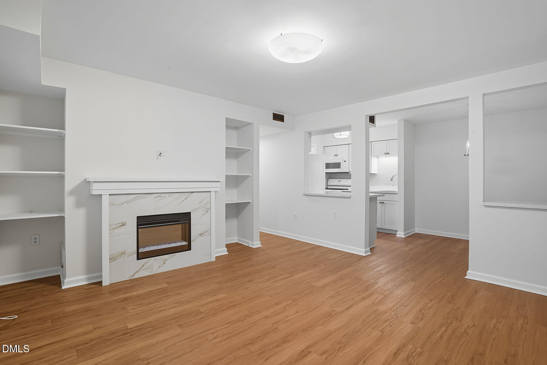 1308 Hillbrow Lane, Unit 203 Raleigh, NC 27615 - Photo 4 of 27 a view of empty room with wooden floor and fireplace
