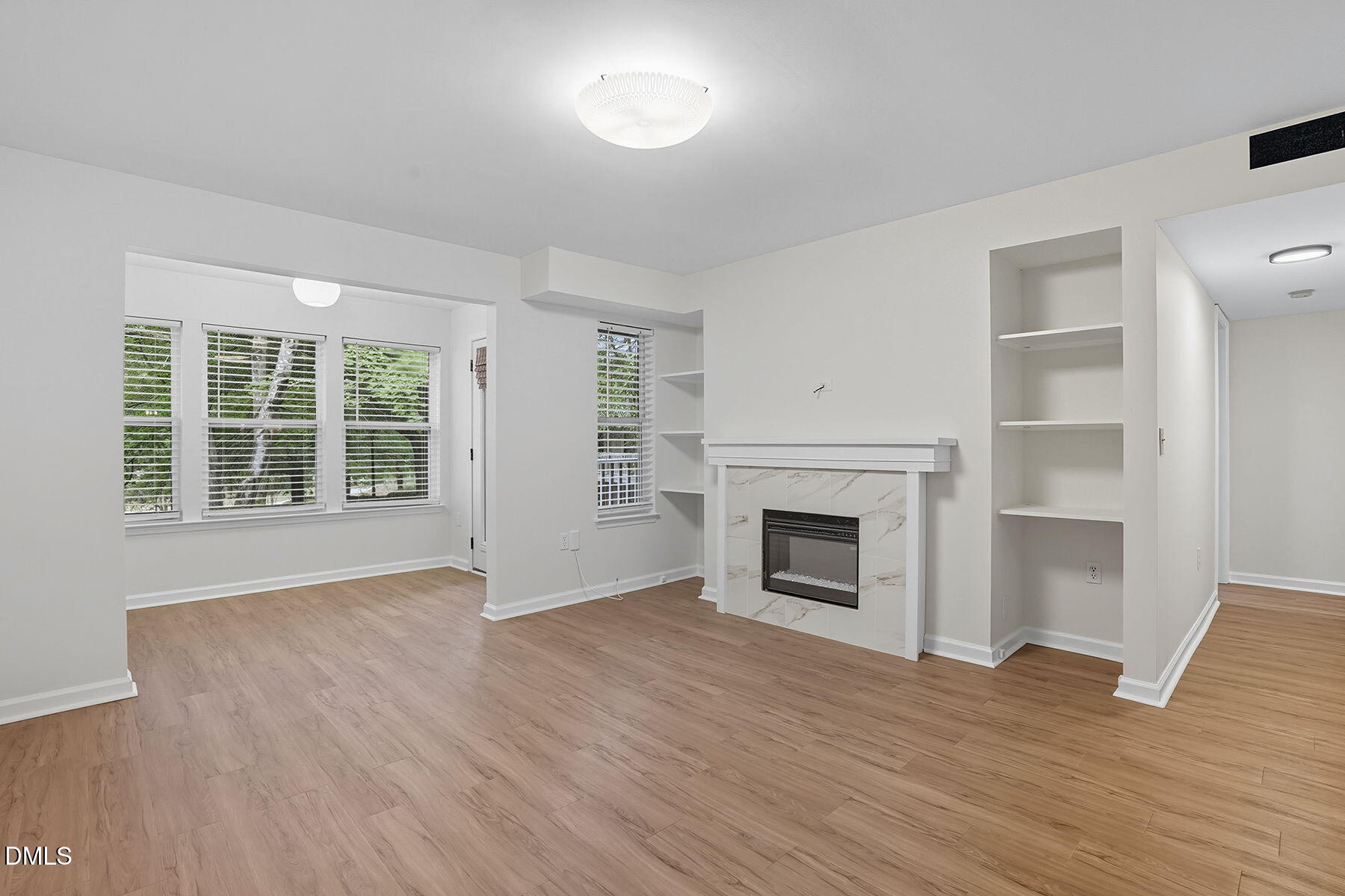 1308 Hillbrow Lane, Unit 203 Raleigh, NC 27615 - Photo 5 of 27 an empty room with wooden floor fireplace and windows