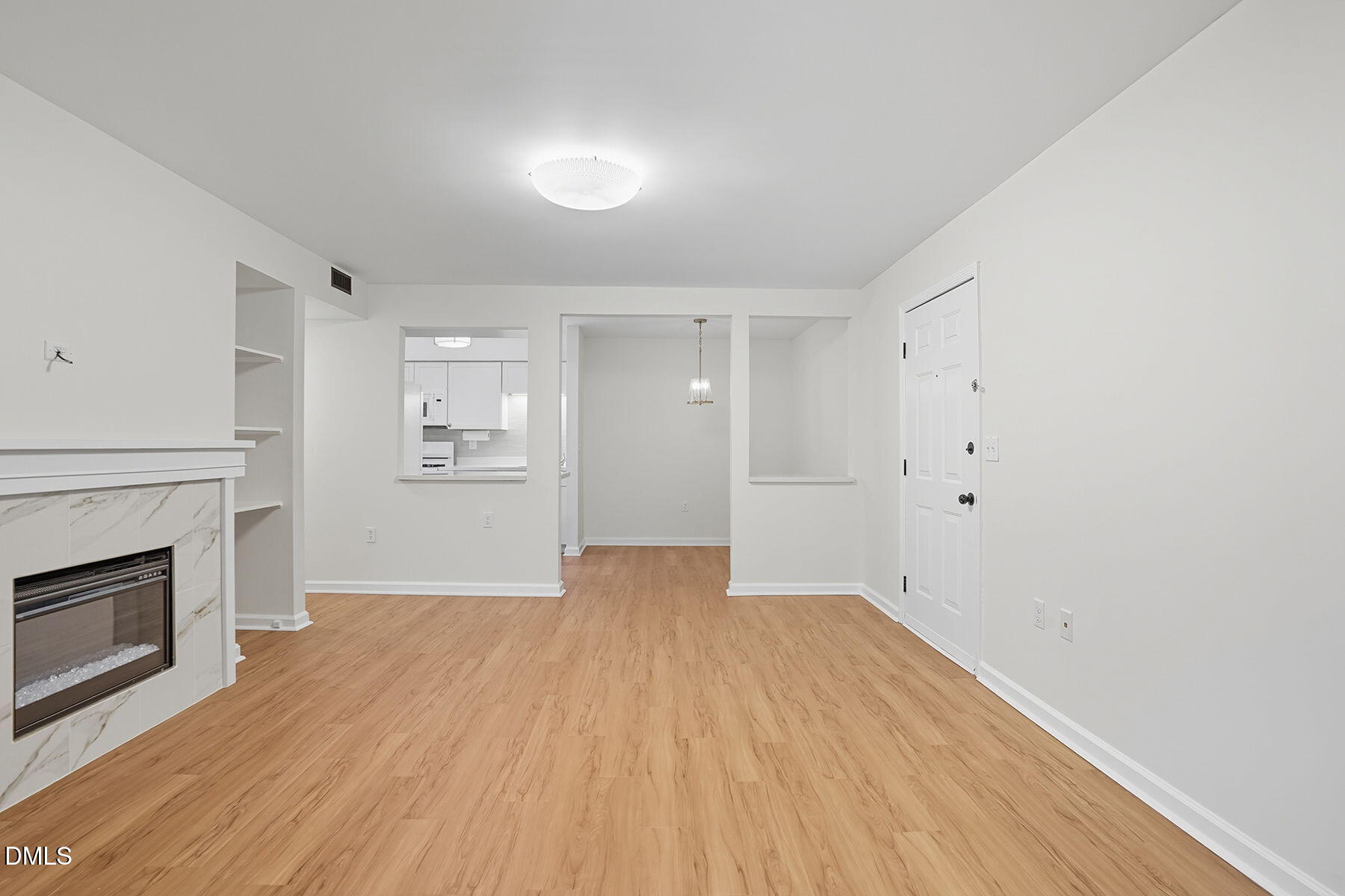 1308 Hillbrow Lane, Unit 203 Raleigh, NC 27615 - Photo 6 of 27 a view of empty room with wooden floor and fireplace