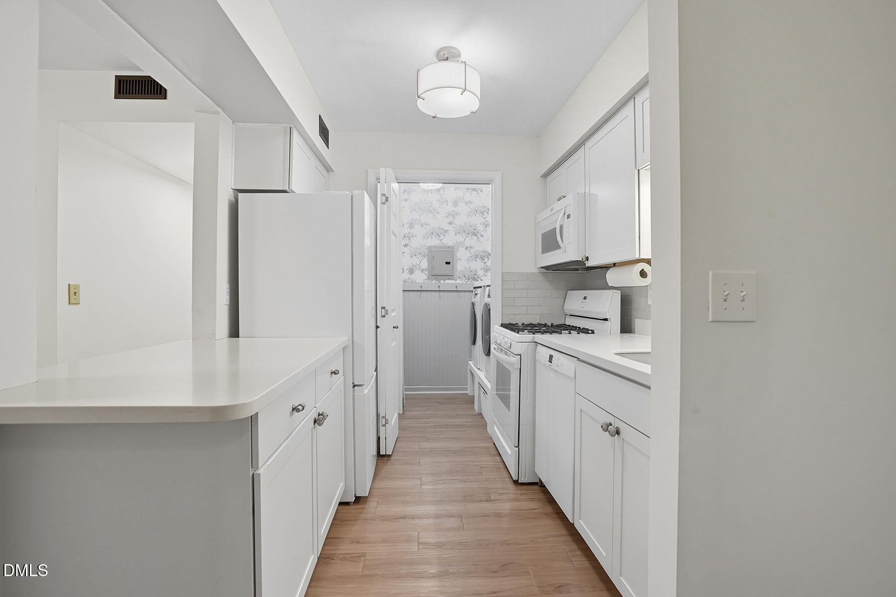 1308 Hillbrow Lane, Unit 203 Raleigh, NC 27615 - Photo 10 of 27 a kitchen with white cabinets and white appliances
