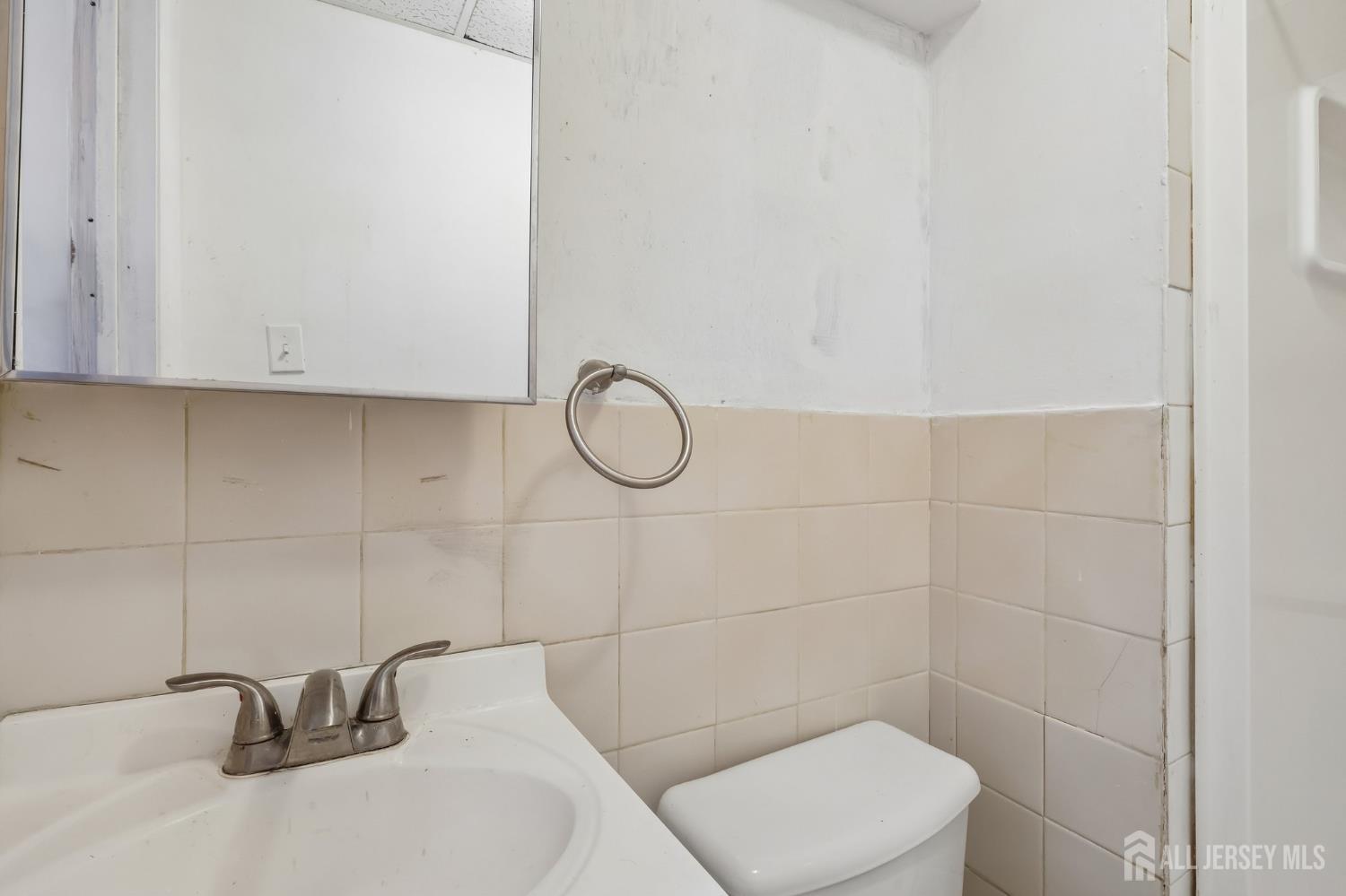 36 Henry Street Edison, NJ 08820 - Photo 35 of 42 a bathroom with a sink a toilet and a mirror