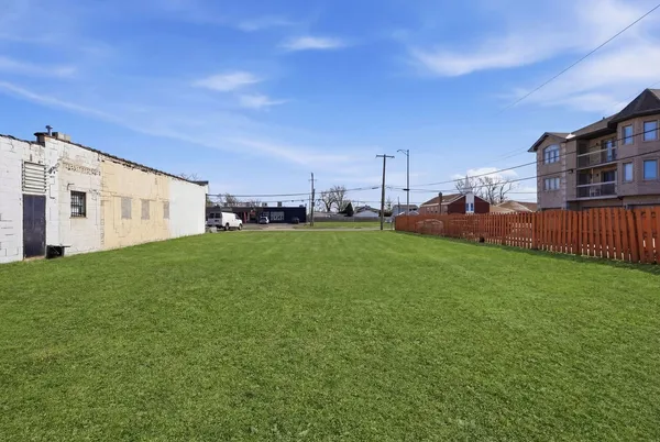 a view of a white house with a big yard