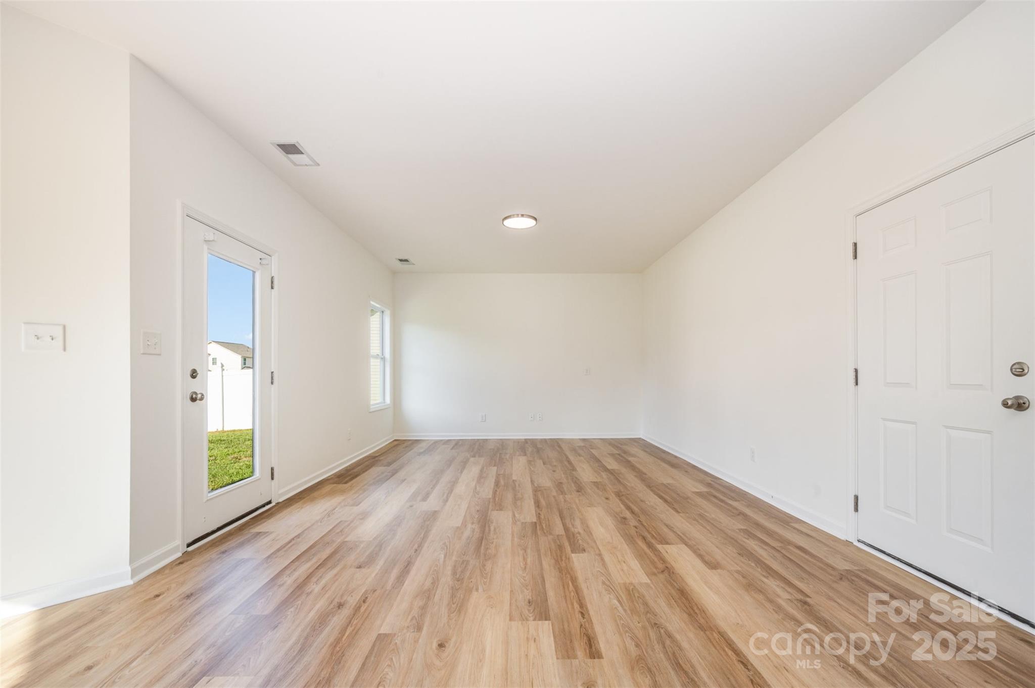 2206 Kingstree Drive Monroe, NC 28112 - Photo 4 of 25 an empty room with wooden floor and windows