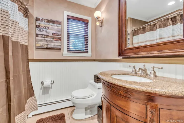 a bathroom with a granite countertop sink toilet and mirror