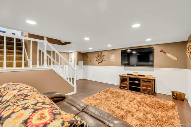 a living room with a flat screen tv and a refrigerator