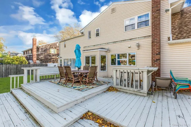 a view of a roof deck with table and chairs wooden floor and fence