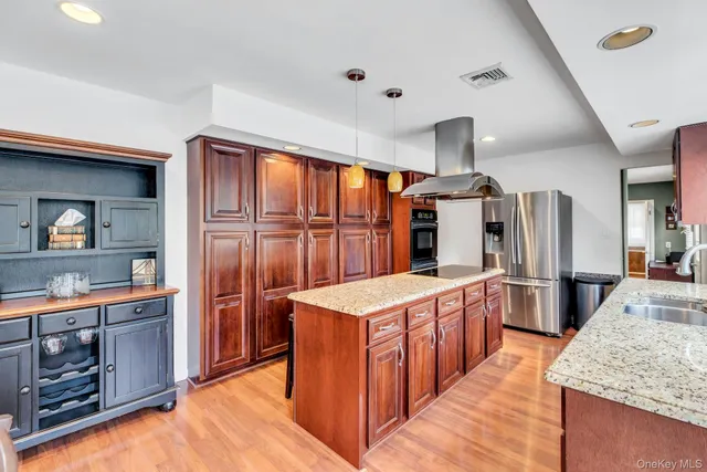 a large kitchen with stainless steel appliances granite countertop a stove oven and refrigerator