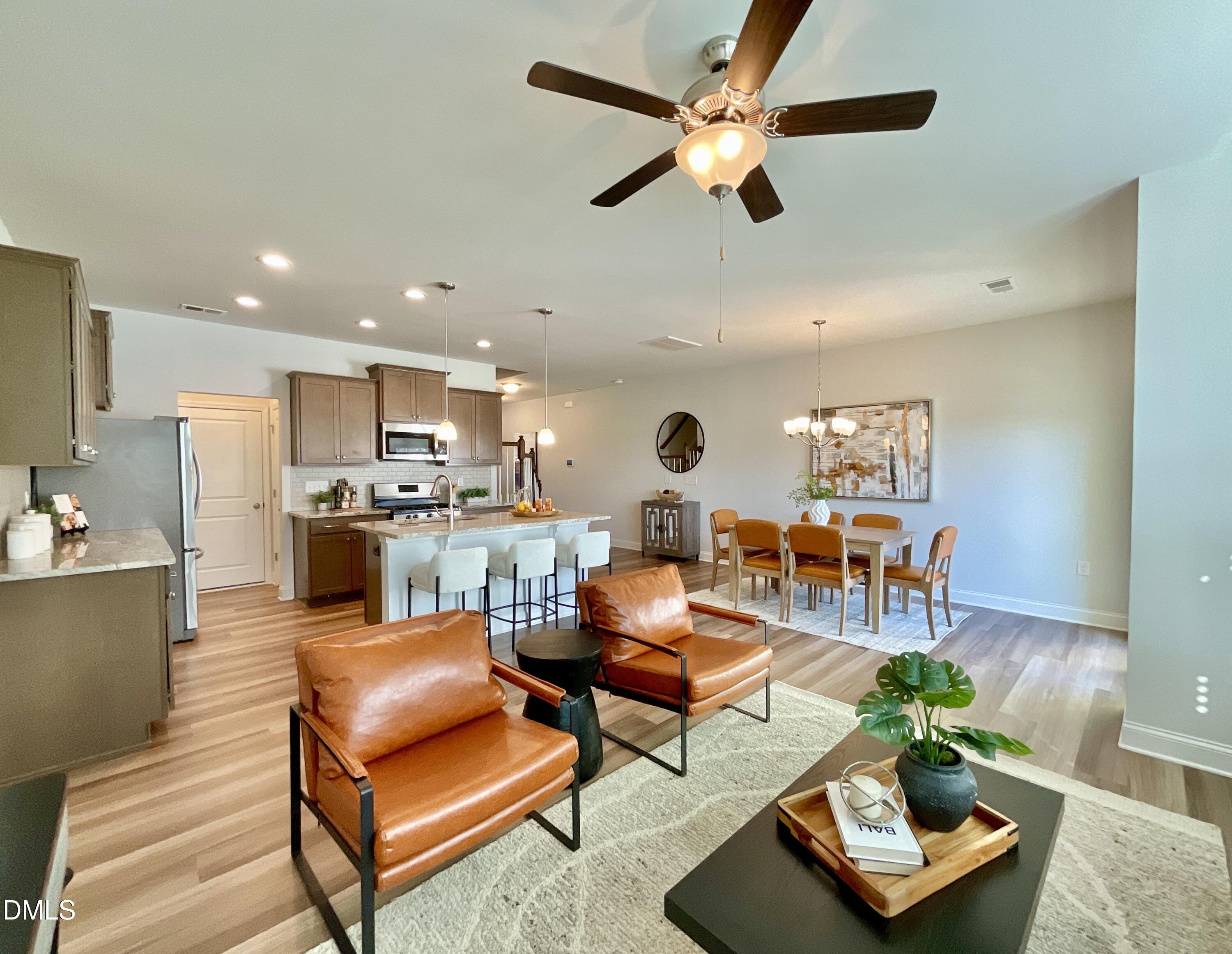 a living room with furniture kitchen view and a chandelier