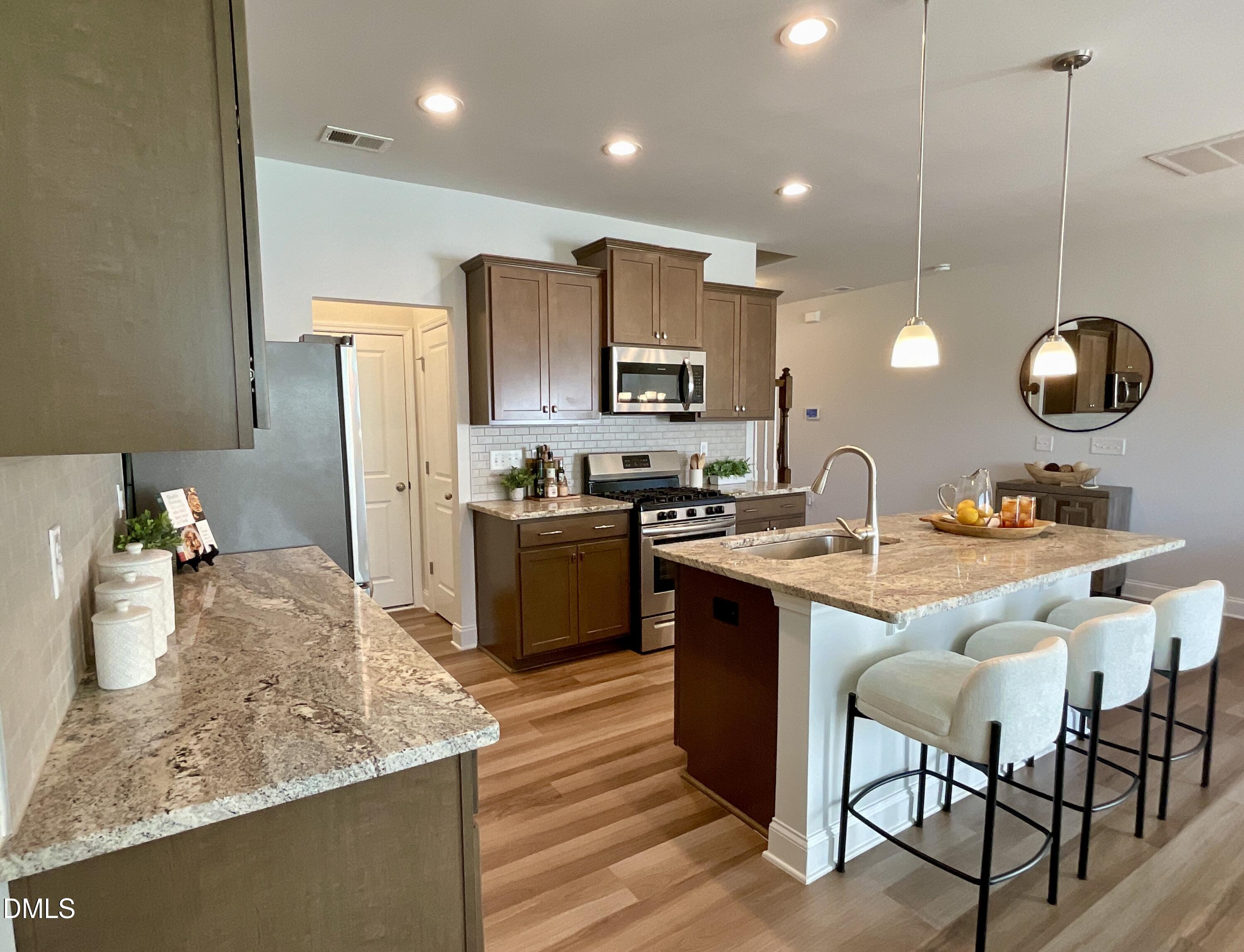 1135 Longitude Drive Durham, NC 27713 - Photo 12 of 37 a kitchen with stainless steel appliances granite countertop a sink refrigerator and cabinets