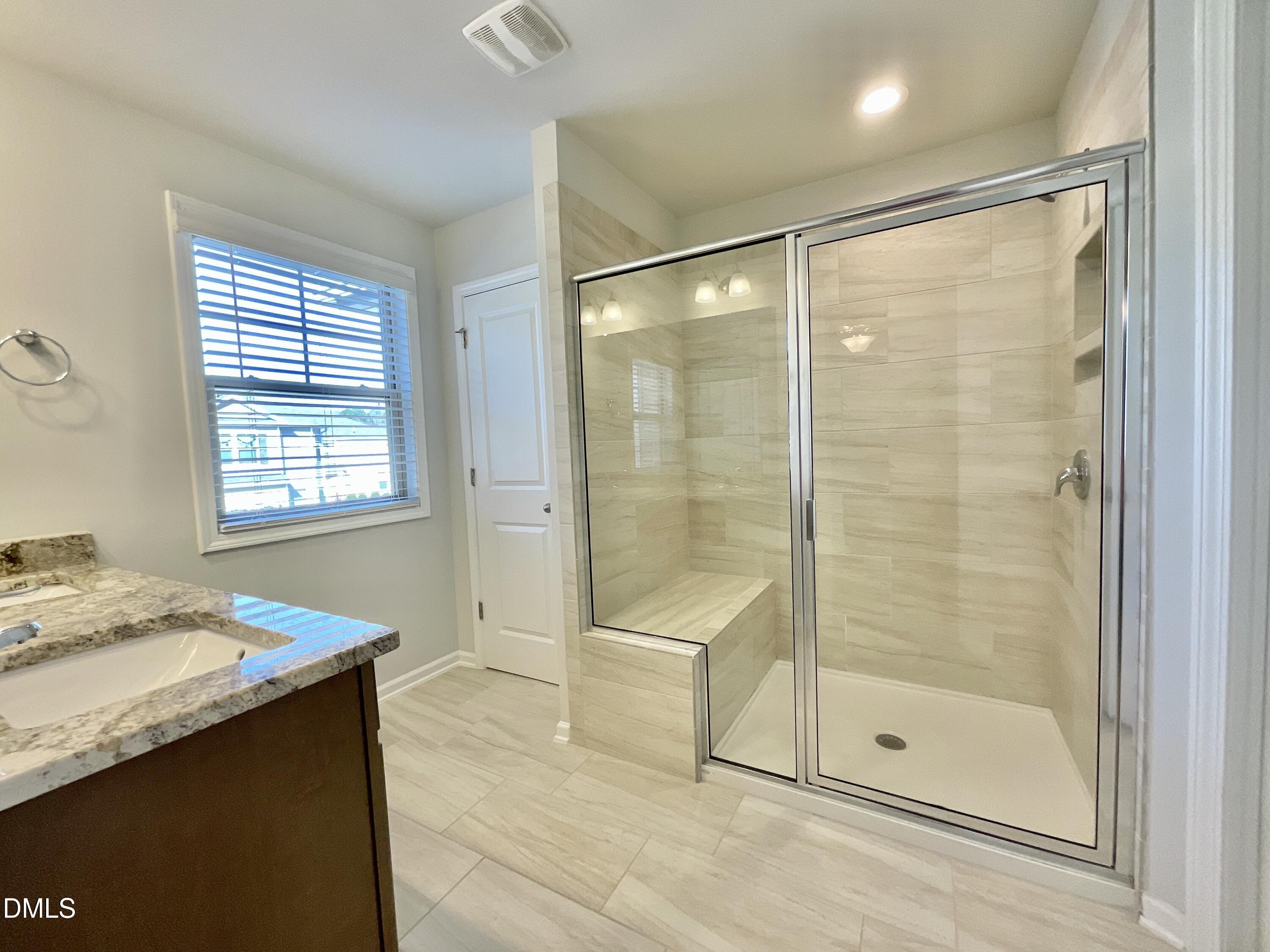 1135 Longitude Drive Durham, NC 27713 - Photo 19 of 37 a bathroom with a granite countertop sink a shower and a mirror