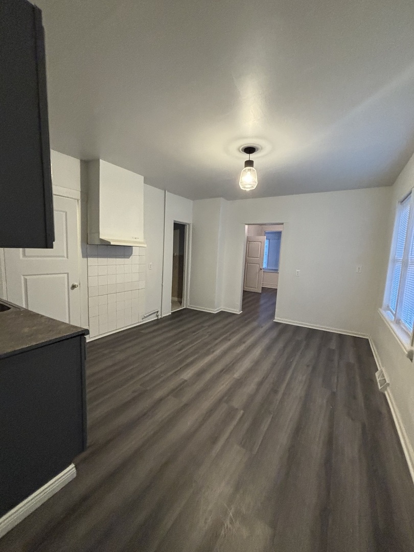 15634 Union Avenue Harvey, IL 60426 - Photo 4 of 34 an empty room with wooden floor and cabinet