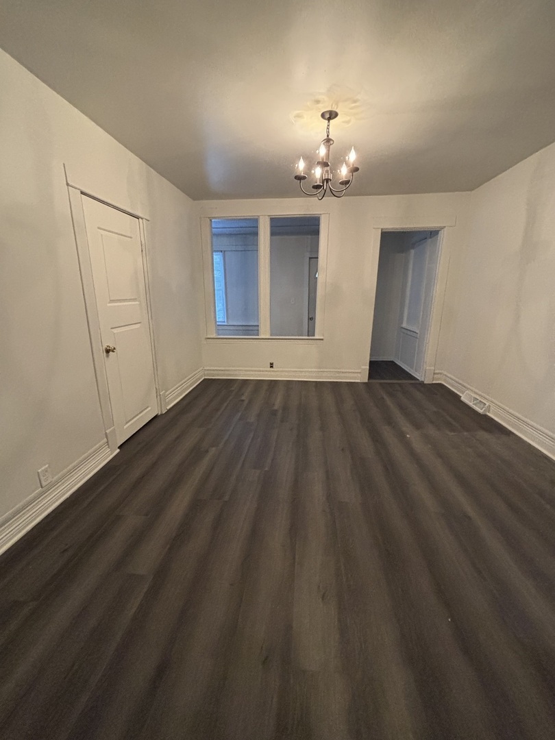 15634 Union Avenue Harvey, IL 60426 - Photo 5 of 34 a view of an empty room with wooden floor and chandelier