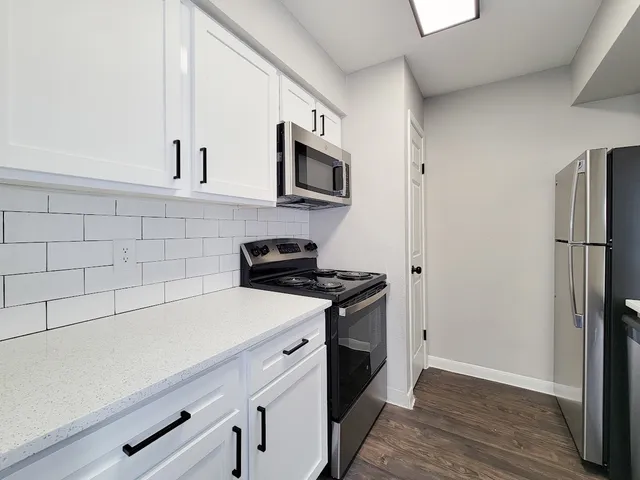 a kitchen with stainless steel appliances a stove microwave and a refrigerator