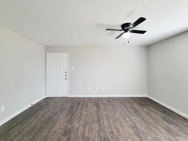 a view of an empty room with wooden floor