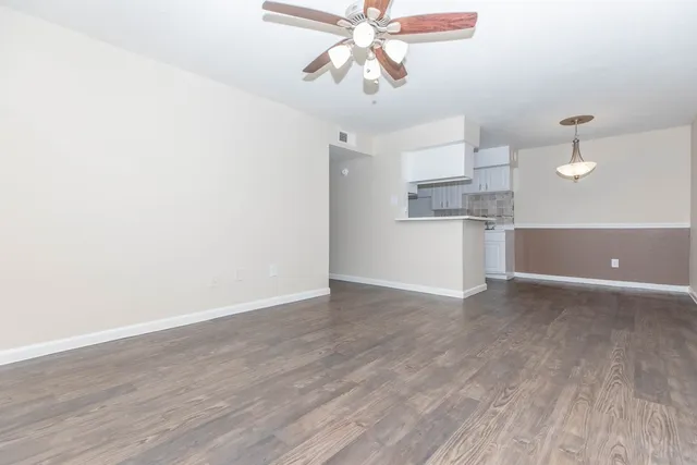 a view of a kitchen with wooden floor and a ceiling fan