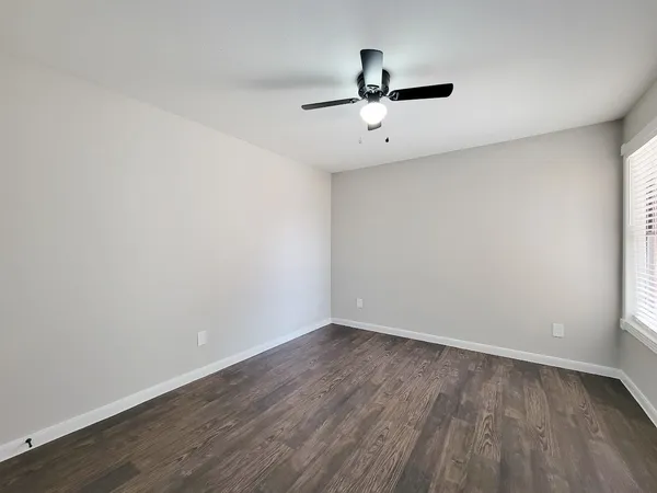 a view of a room with wooden floor and ceiling fan