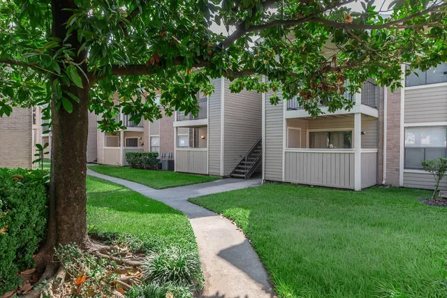 a view of a house with backyard and a tree