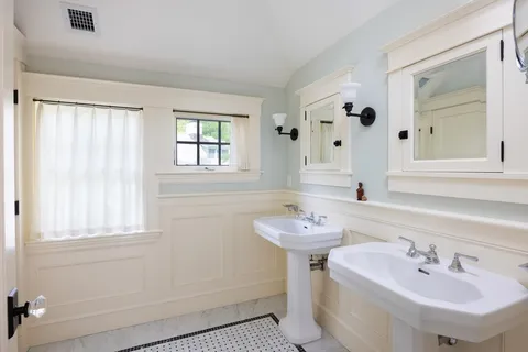 a bathroom with 2 sink and a mirror