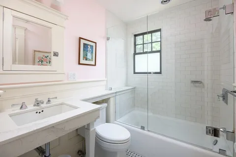 a bathroom with a sink toilet a mirror and shower