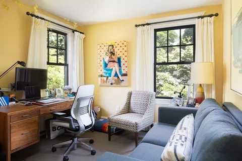 a view of a livingroom with workspace and a window