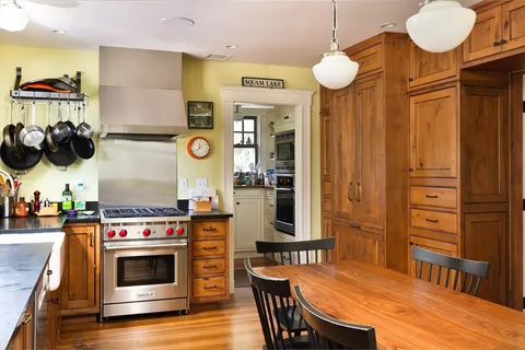a kitchen with a wooden floor and breakfast area
