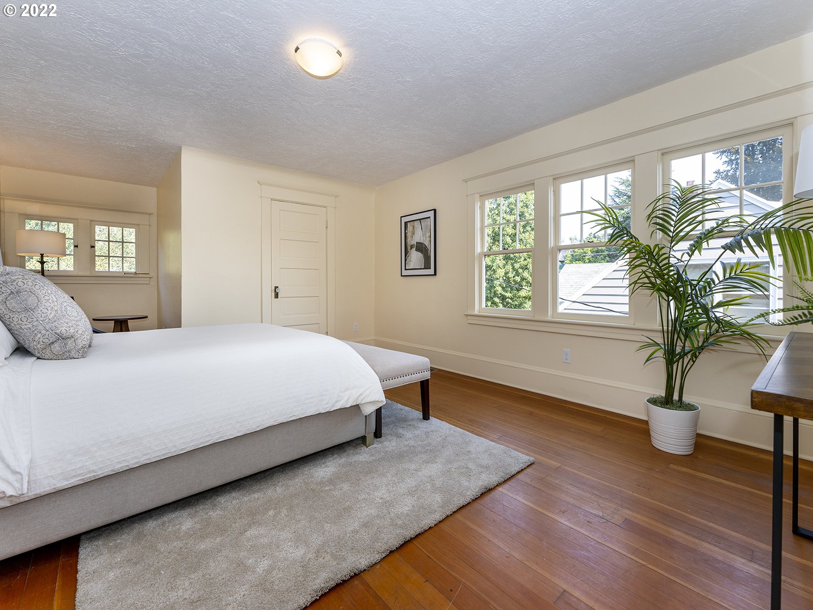 2424 Southeast Caruthers Street Portland, OR 97214 - Photo 16 of 32 a bedroom with a bed and a potted plant