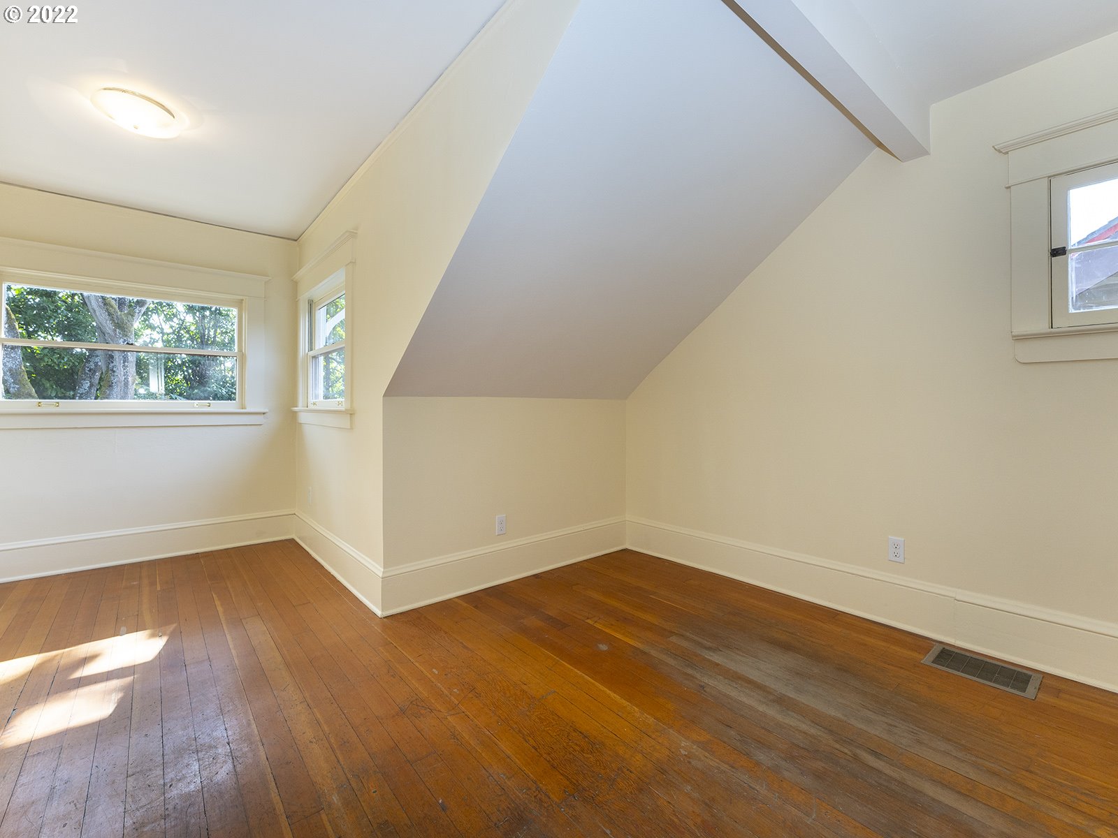 2424 Southeast Caruthers Street Portland, OR 97214 - Photo 19 of 32 an empty room with wooden floor and windows