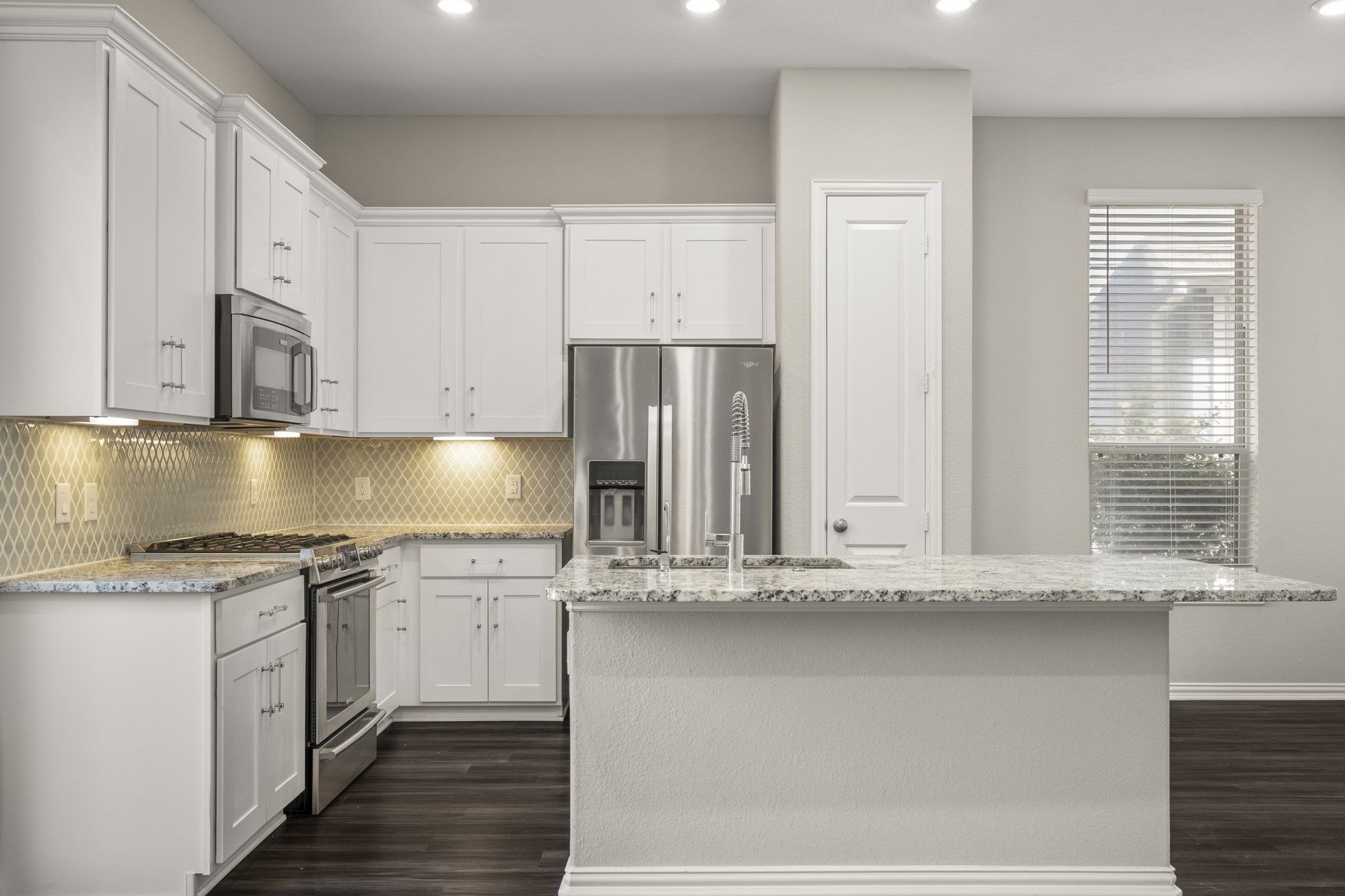 162 Moon Dance Court Conroe, TX 77304 - Photo 9 of 36 a kitchen with stainless steel appliances granite countertop a sink and a stove
