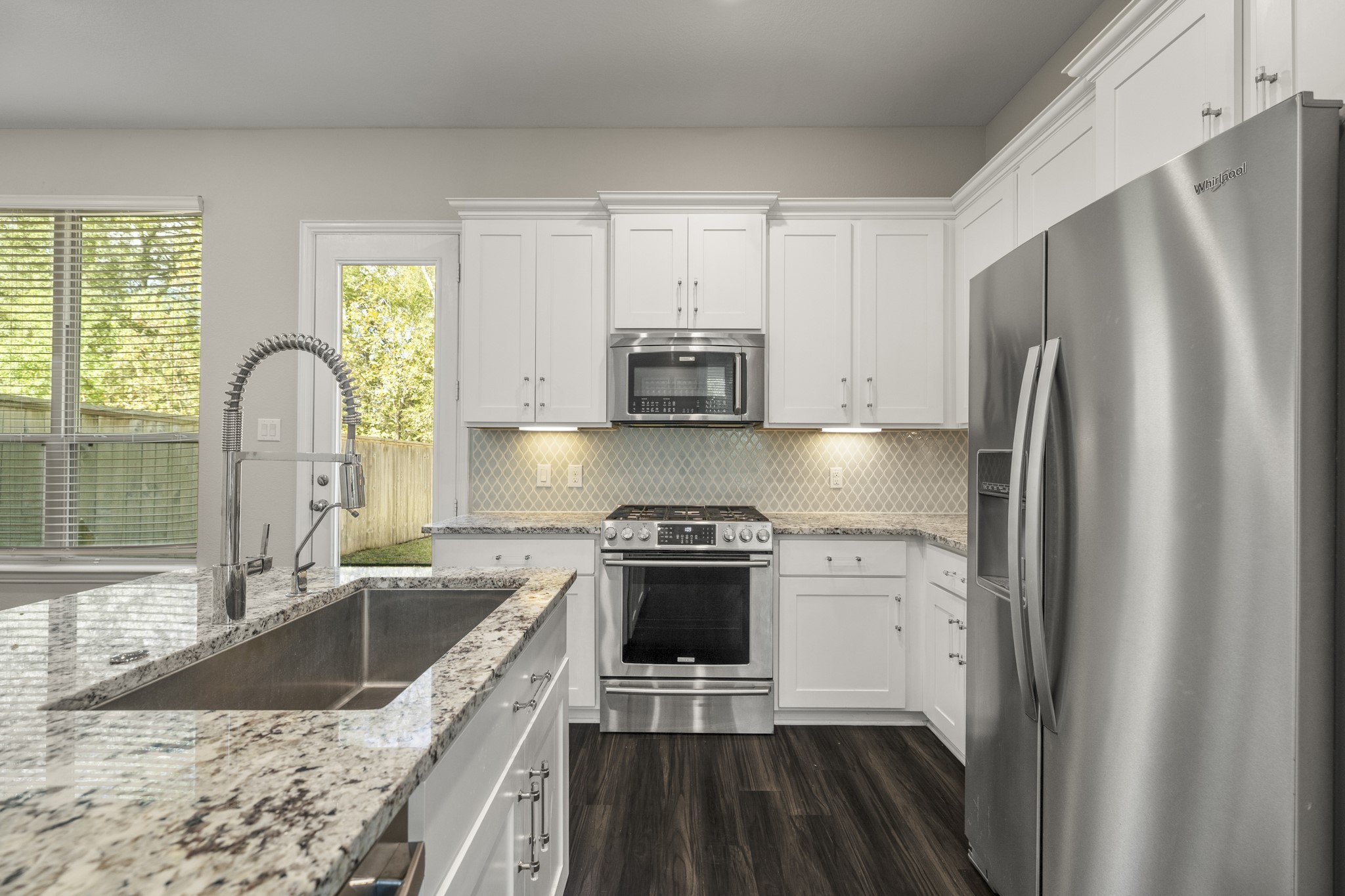 162 Moon Dance Court Conroe, TX 77304 - Photo 10 of 36 a kitchen with a stove a sink and a refrigerator