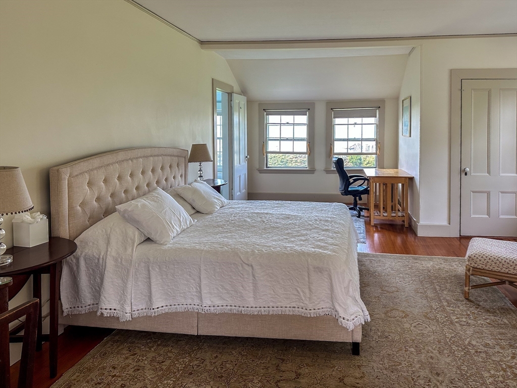 48 Proctor Street Manchester, MA 01944 - Photo 15 of 39 a spacious bedroom with a bed a table and windows