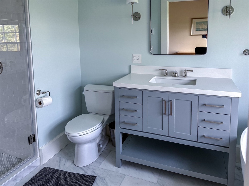 48 Proctor Street Manchester, MA 01944 - Photo 18 of 39 a bathroom with a sink toilet a mirror and vanity