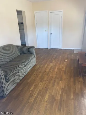 a view of a bedroom with wooden floor