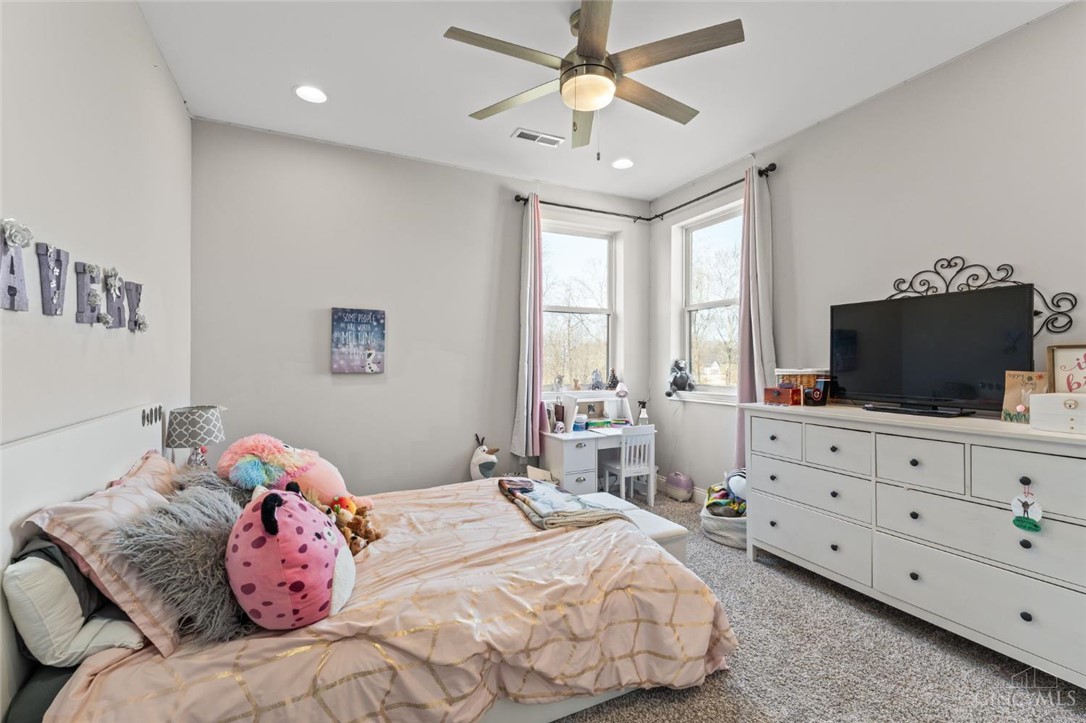 2425 Middleboro Road Clarksville, OH 45113 - Photo 84 of 91 This cozy bedroom features bright windows, soft carpet, and a ceiling fan for comfort.