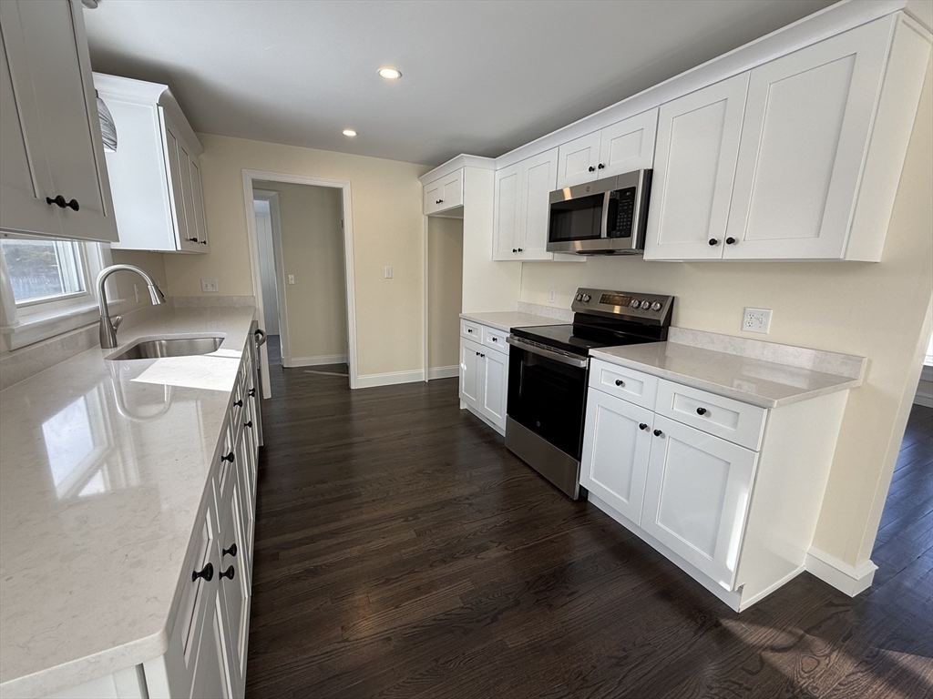 30 Alroy Road Weymouth, MA 02190 - Photo 17 of 40 a kitchen with stainless steel appliances granite countertop a stove top oven a sink a refrigerator white cabinets and wooden floor