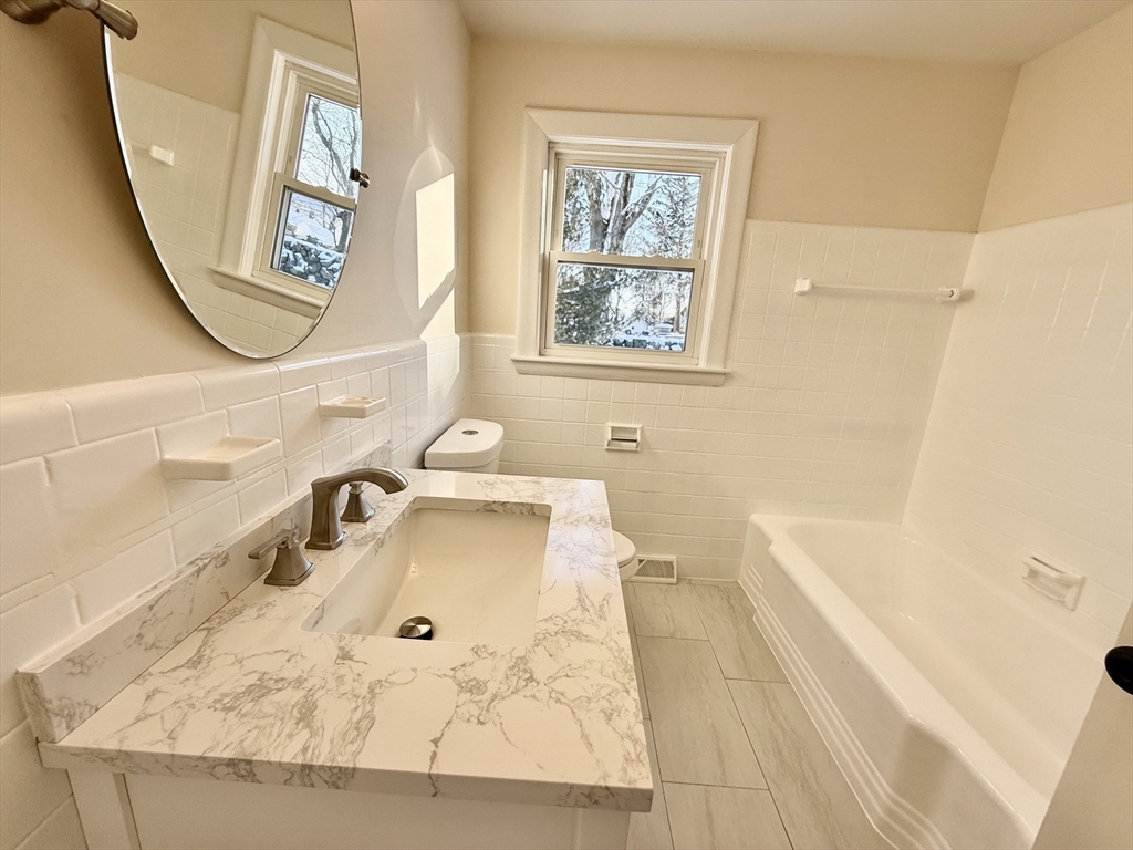 30 Alroy Road Weymouth, MA 02190 - Photo 20 of 40 a bathroom with a tub sink and a mirror