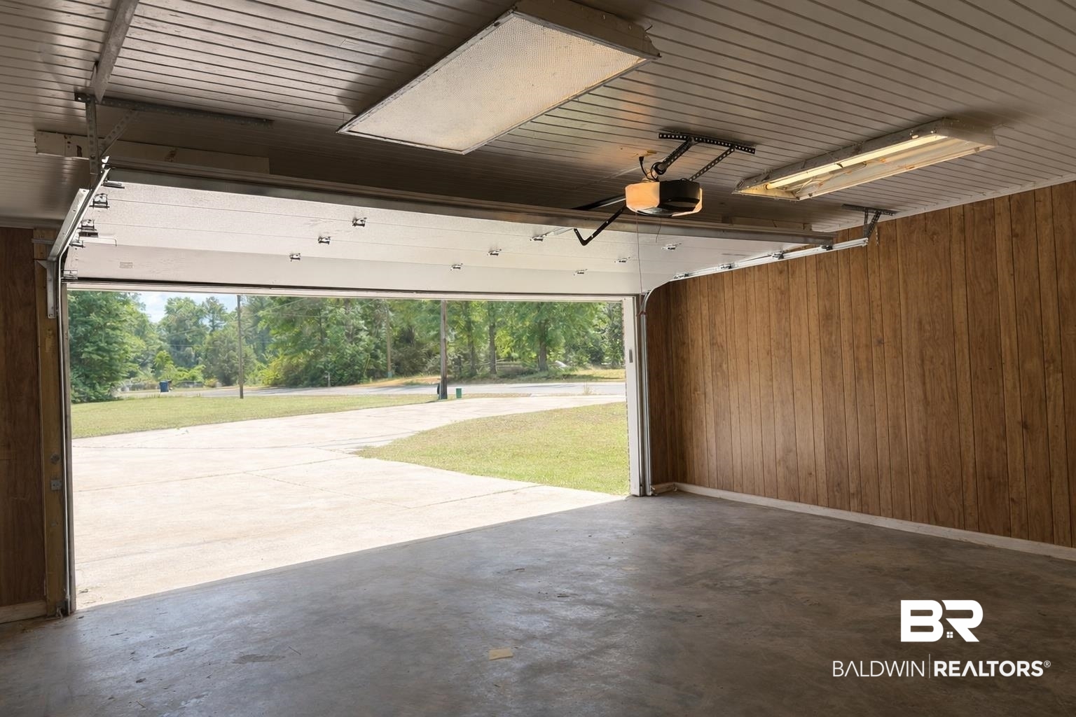 294 Wolf Log Road Flomaton, AL 36441 - Photo 14 of 14 Garage with wooden walls, wooden ceiling, and a garage door opener